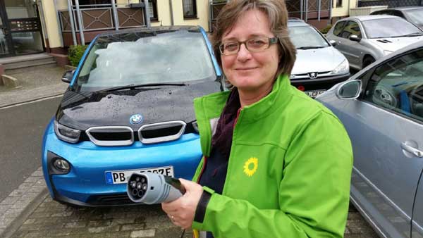 Grüne Landtagskandidatin Norika Creuzmann vor einem E-Auto, das auch in Altenbeken präsentiert wird.