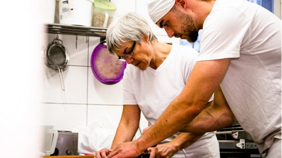 Zwei Menschen arbeiten in Bäckerei.