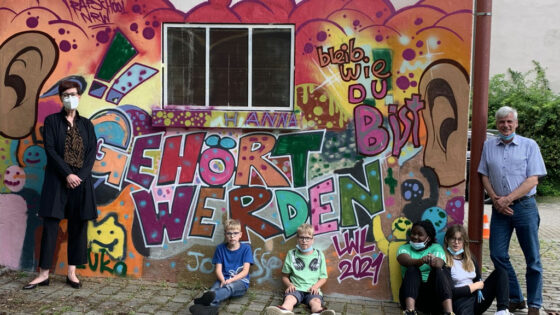 Gruppenfoto vor einer Graffiti-Wand