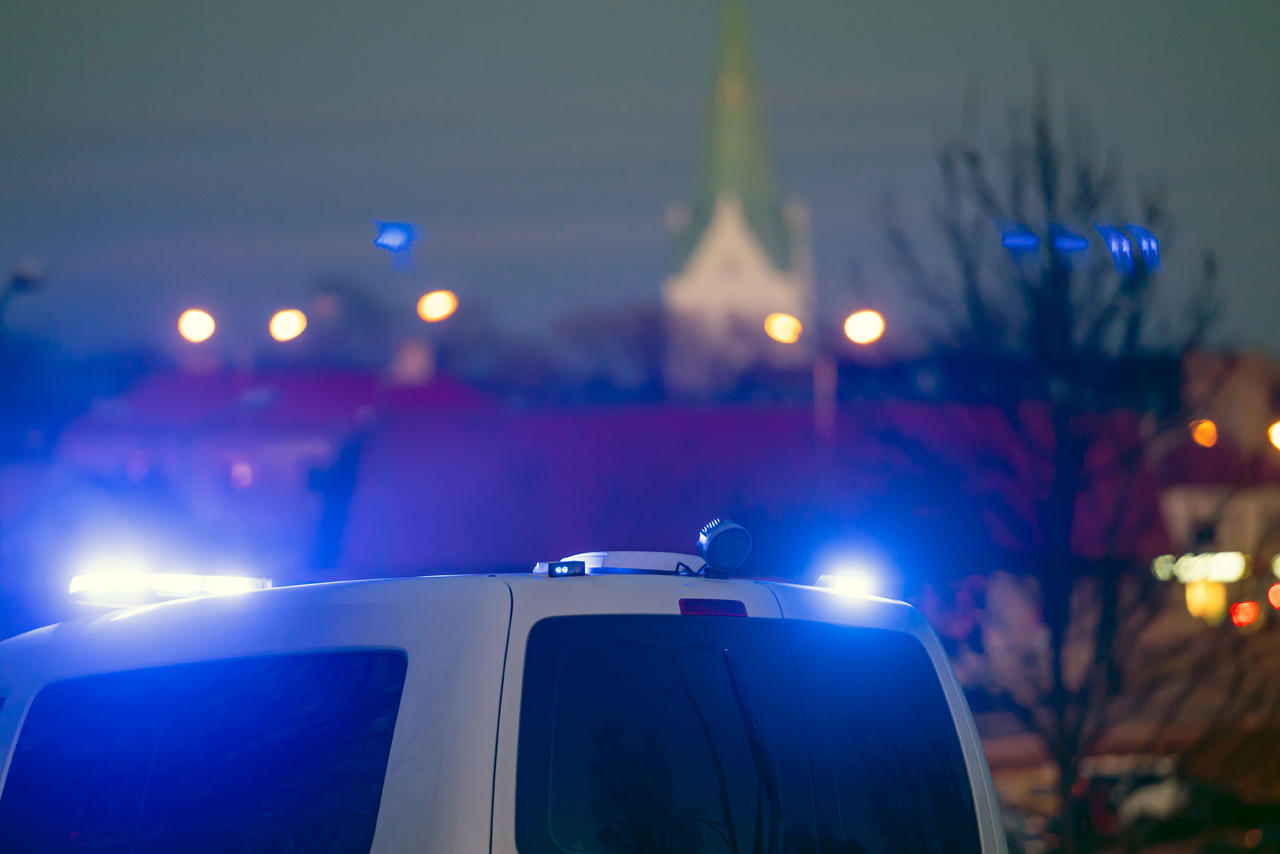 Polizeibulli und im Hintergrund Stadtlichter und Kirchturm