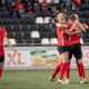 Fußballspielerinnen umarmen sich auf dem Feld.