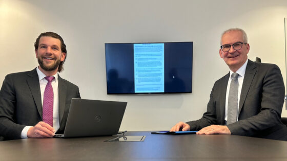 zwei Deutsche Bank Mitarbeiter im Konferenzraum am Tisch sitzend.