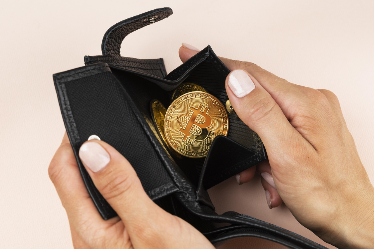 Symbolisch für Bitcoin-Wallet. Frauenhände halten Geldbörse mir Bitcoints in Händen.